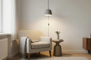 Minimalist reading corner featuring a grey armchair, a wooden side table, and a modern grey plug-in pendant lamp hanging directly above.