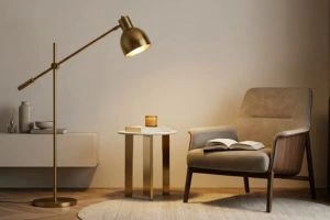 Cozy reading area featuring a modern brass pharmacy floor lamp illuminating a beige armchair with an open book, next to a small side table.